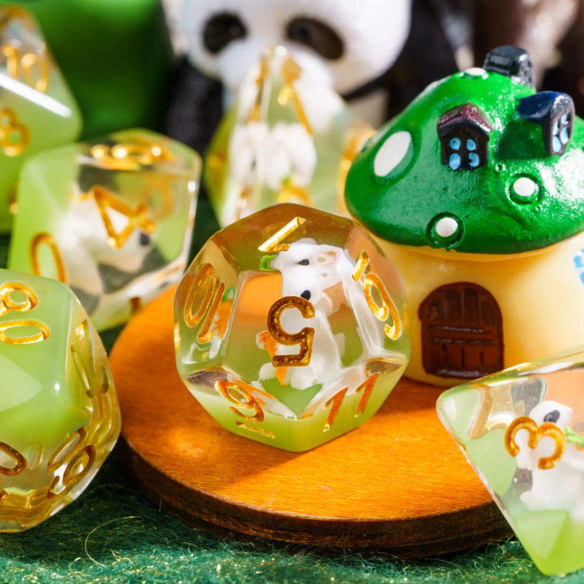 A set of adorable animal resin dice, including a house and a panda, resting on a wooden surface.