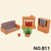 A miniature dollhouse set featuring a wooden fireplace, a sofa with a checkered cushion, and a wooden cabinet.