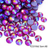 A close-up of various iridescent and holographic rhinestones in shades of purple, pink, and blue.