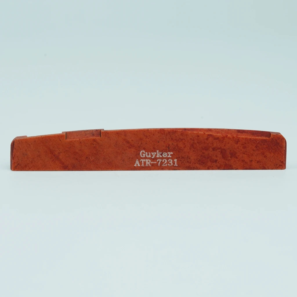 An orange-brown acoustic guitar bridge saddle made of cow bone with the name Guyker ATR-7231 engraved on it.
