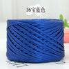 A spool of metallic blue flat ribbon yarn for crochet and knitting, showing its texture and color.