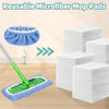 Stack of blue and white microfiber mop pads with a green mop handle and pad on a wooden floor.