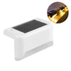 A white solar deck light with a dark panel, shown next to an inset image demonstrating its outdoor illumination.