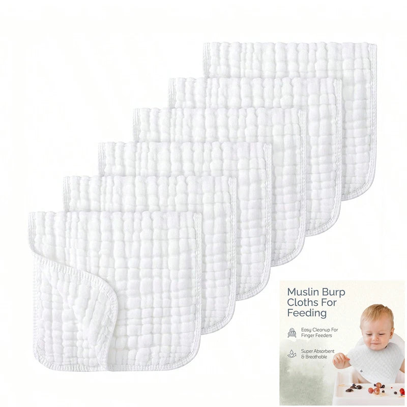 A stack of white muslin burp cloths for feeding, showing various sizes and textures.