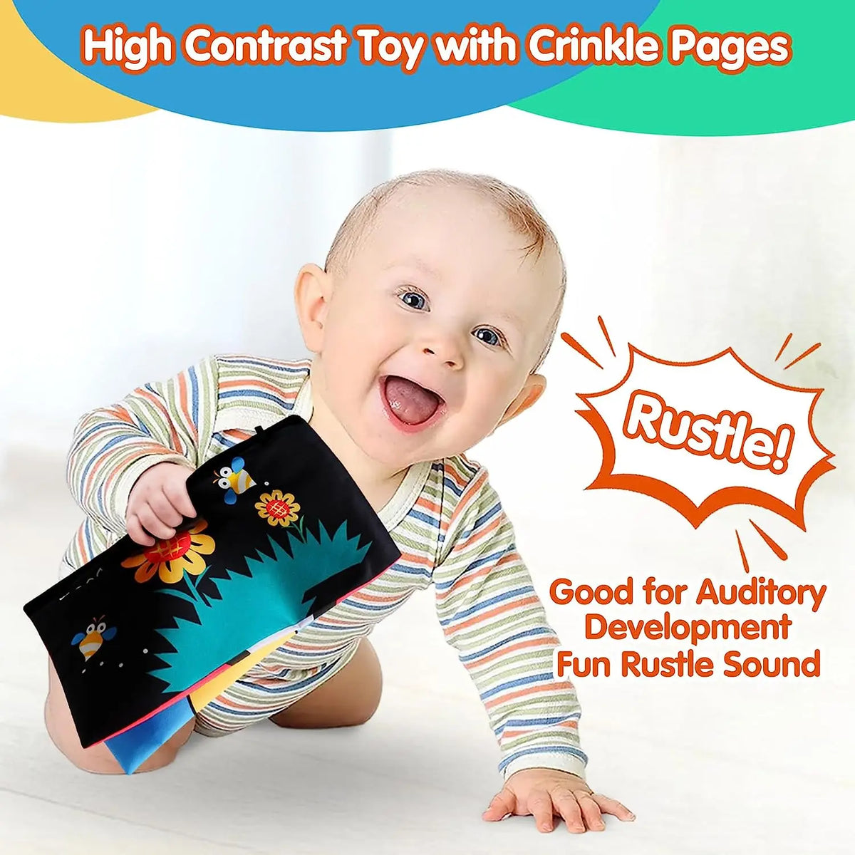 A baby is smiling while holding a high contrast toy with crinkle pages for auditory development.