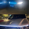 Close-up of a white vehicle's front grille with an illuminated LED light strip and scan effect.