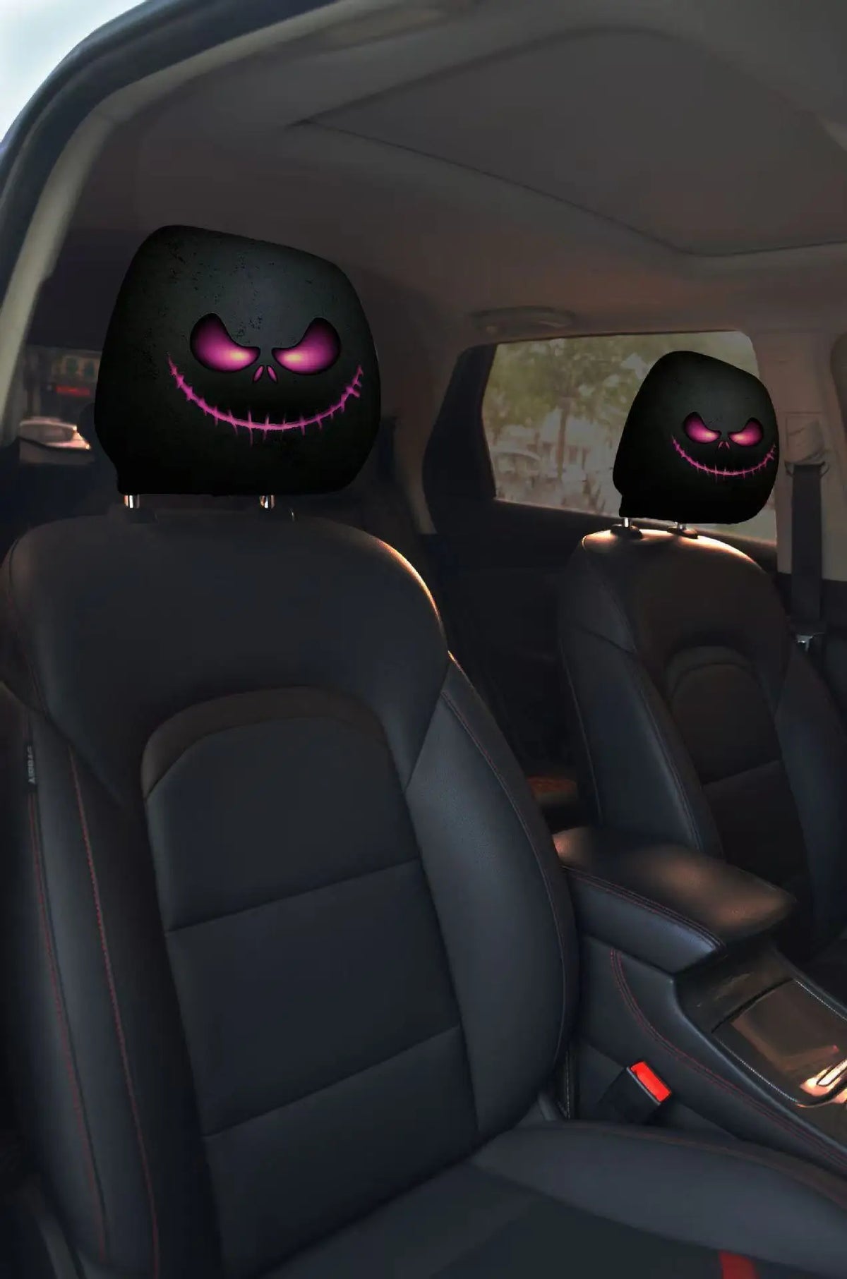 A pair of black car headrest covers featuring creepy purple smiling face designs.