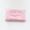 A pink soft cotton baby pillowcase featuring a pattern of small crowns.
