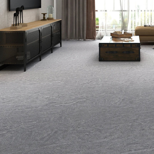 A modern living room featuring gray carpet, a dark wooden cabinet, and a rectangular wooden chest on the floor.