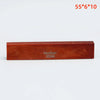 A rectangular piece of reddish-brown wood labeled Guykor 5560, used as an acoustic guitar bridge saddle.