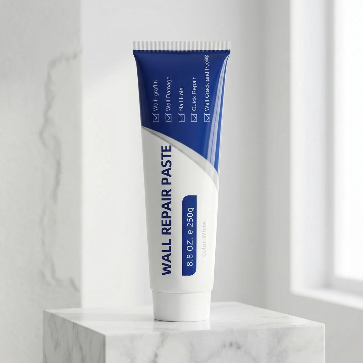 A tube of Wall Repair Paste contains a scraper and sandpaper for quick drywall repairs, displayed on a white marble surface.