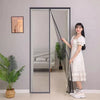 A young woman stands next to a modern sliding glass door with a magnetic screen curtain installed.