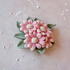 A pink rose bloom silicone mold for chocolates and candy rests on a light surface.