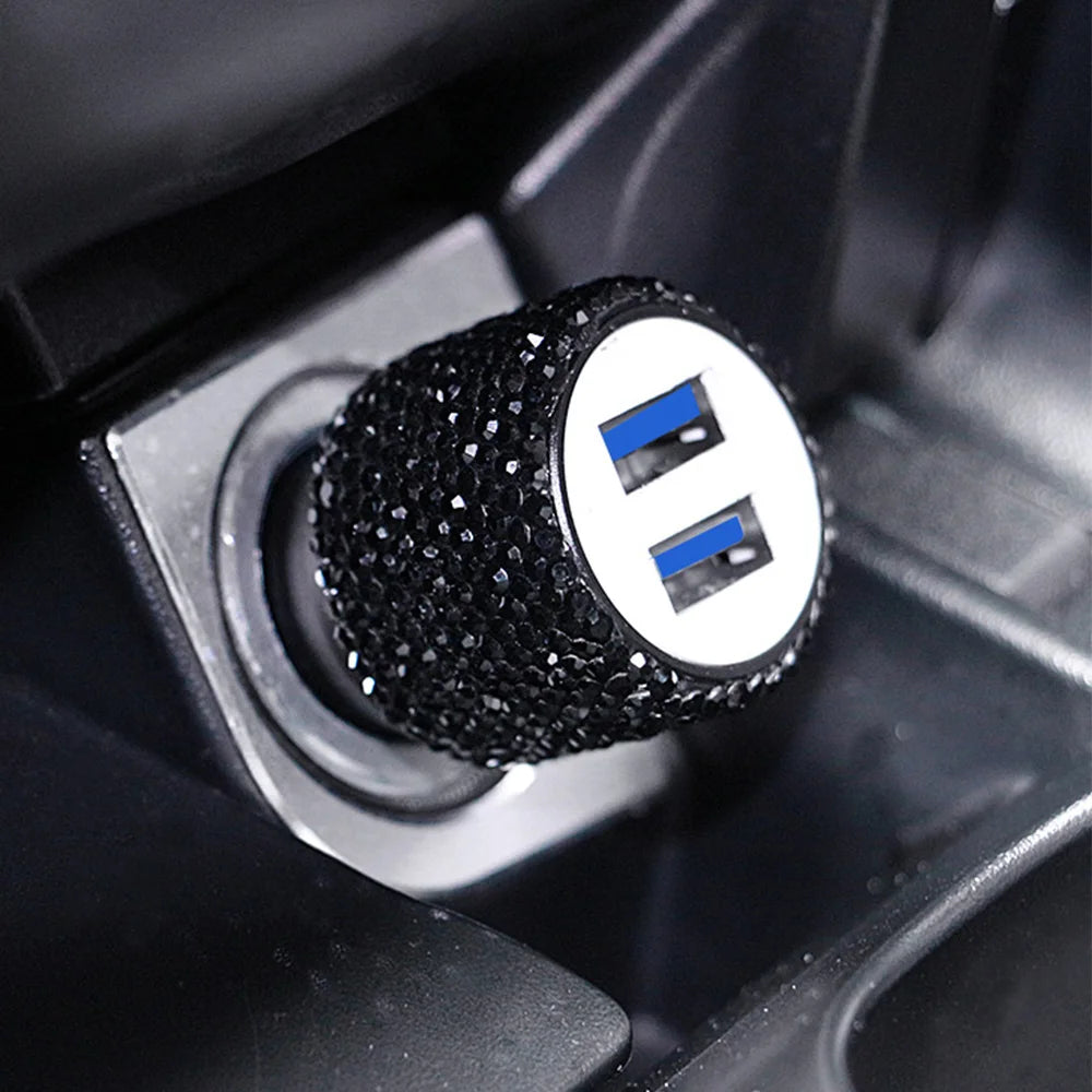 Close-up of a black rhinestone dual USB car charger with blue accents inside a device slot.