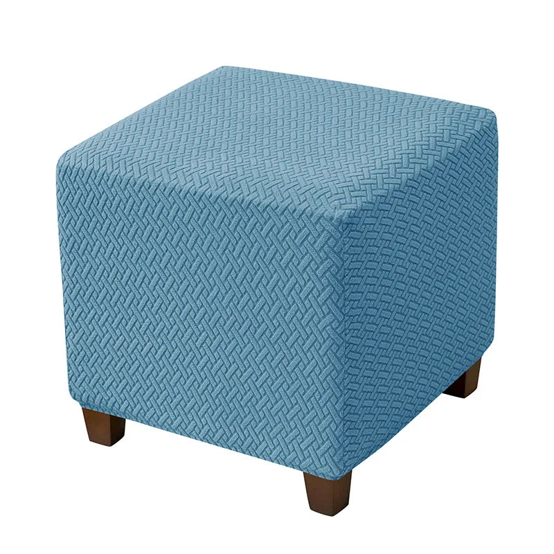 A square ottoman slipcover in a light blue color with a diamond lattice pattern.