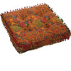An orange and red bohemian cotton linen floor cushion with decorative fringe.