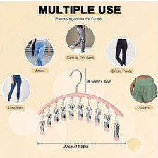 A pink hanger with multiple clips is shown organizing various types of pants like jeans, dress pants, leggings, and shorts fo