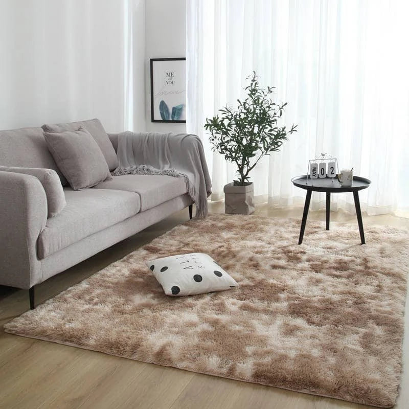 A plush, brown velvet carpet is displayed in a bright room with a sofa and a small side table.