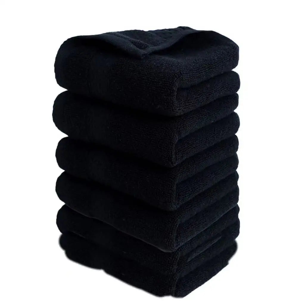 A stack of six black premium pure cotton face towels.
