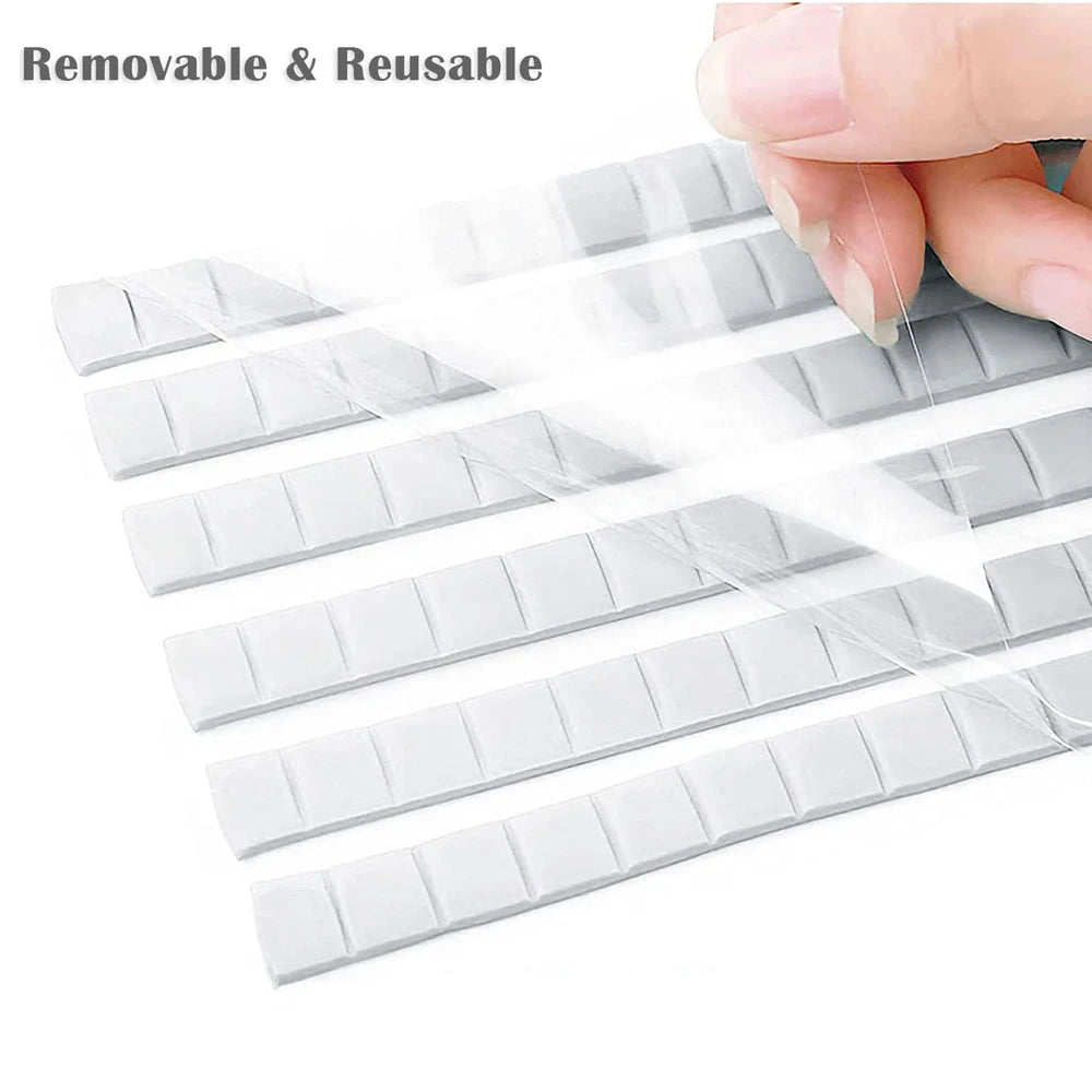 A hand is holding and displaying multiple strips of removable and reusable nail glue clay for shelf fixing.