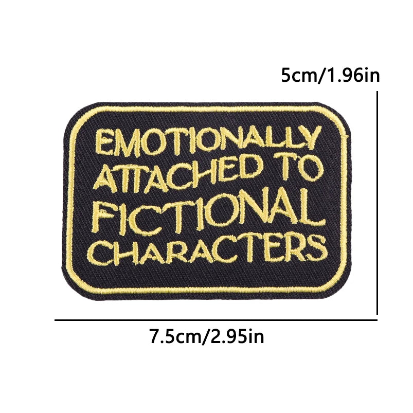 Black embroidered iron-on patch with yellow text that reads Emotionally Attached to Fictional Characters