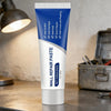 A tube of Wall Repair Paste for drywall repair is shown on a wooden surface.