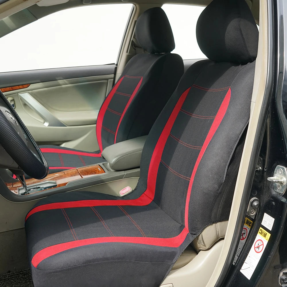 A black car seat cover set with red stitching and accents shown inside a vehicle cabin.