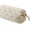 A beige quilted storage bag for a portable hair dryer and styling tool with a fabric strap.