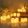 A collection of glowing white LED tea lights arranged on a wooden surface and a tiered stand, set against a soft, warm backgr