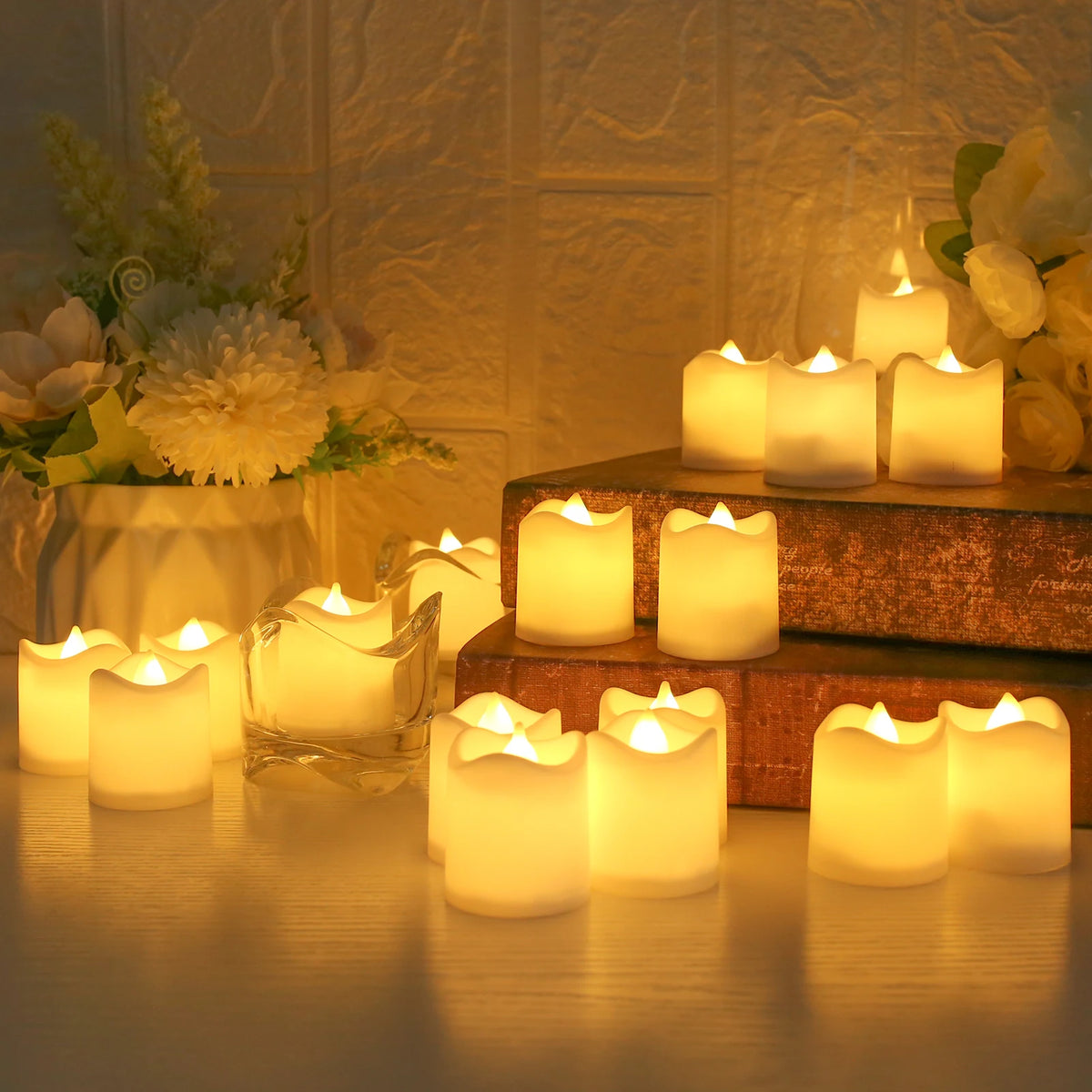 A collection of glowing white LED tea lights arranged on a wooden surface and a tiered stand, set against a soft, warm backgr