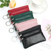 A collection of stacked compact PU leather coin purses in red, green, pink, and black with silver hardware.