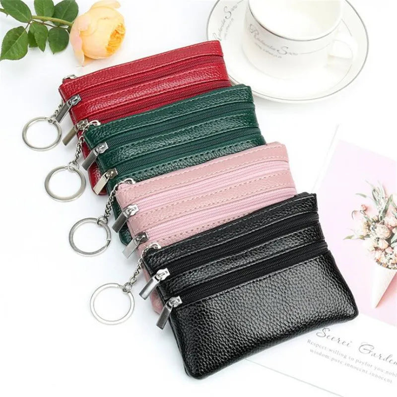 A collection of stacked compact PU leather coin purses in red, green, pink, and black with silver hardware.