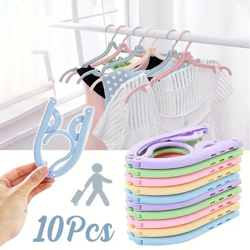 A set of ten light colored foldable travel clothes hangers with anti-slip grips are displayed next to a hand and a person ico