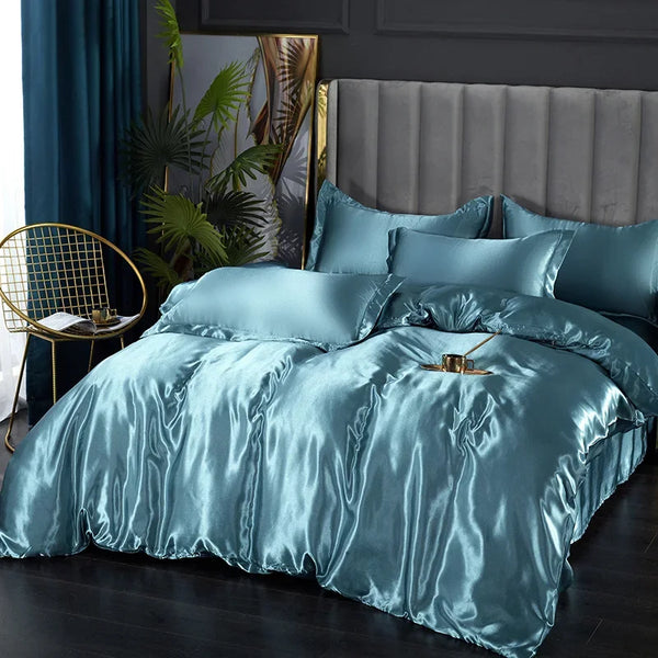 A luxurious teal satin duvet cover and bedding set displayed on a bed with a gray upholstered headboard.