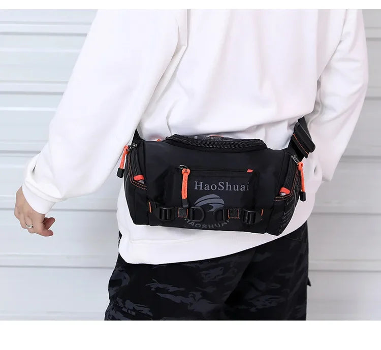 A black tactical chest bag worn by a person, featuring orange accents, is shown against a light background.