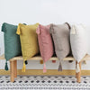 A row of nine cotton linen throw pillow covers in various muted colors like sage green, mustard yellow, pink, and gray with t