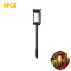 A black solar path light fixture with a yellow glow, designed for waterproof outdoor landscape lighting.