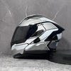 A silver and black DOT-approved modular flip-up motorcycle helmet displayed against a gray marble background.