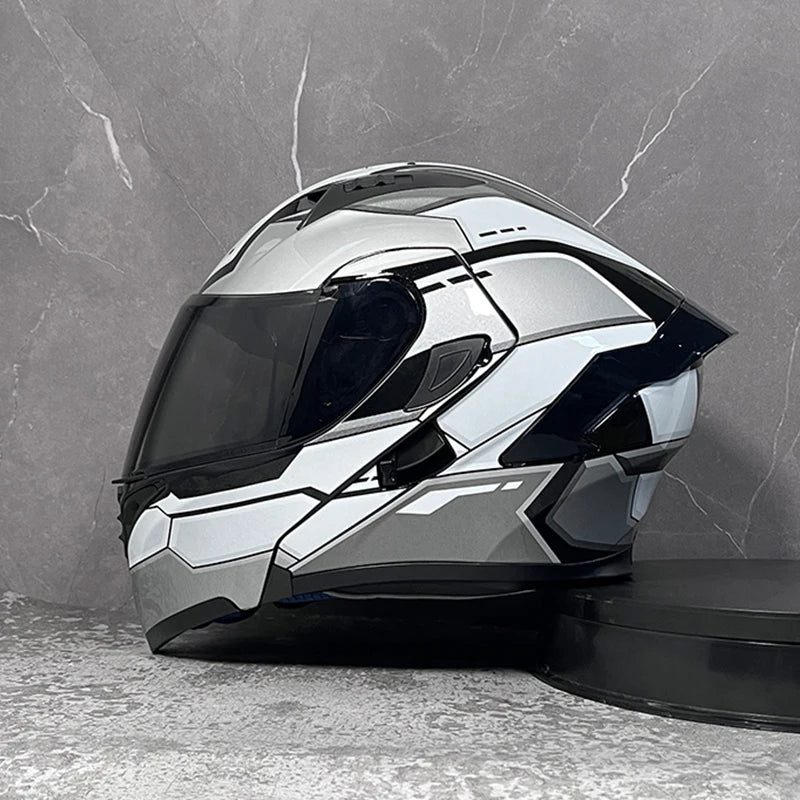 A silver and black DOT-approved modular flip-up motorcycle helmet displayed against a gray marble background.