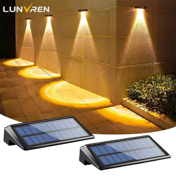 Two solar-powered LED lights illuminating a stone deck and fence area at night.