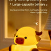 A yellow silicone night light shaped like a pig sitting on a wooden surface.