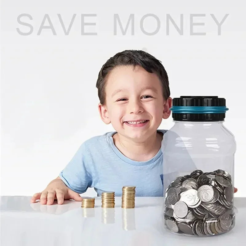 A smiling boy sits next to a clear glass jar filled with silver coins on a white surface.