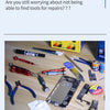 A collection of various repair tools, including screwdrivers, pliers, and knives, laid out on a wooden surface.