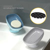 A blue suction cup soap holder with a white soap disc is shown next to a gray ceramic soap dish.
