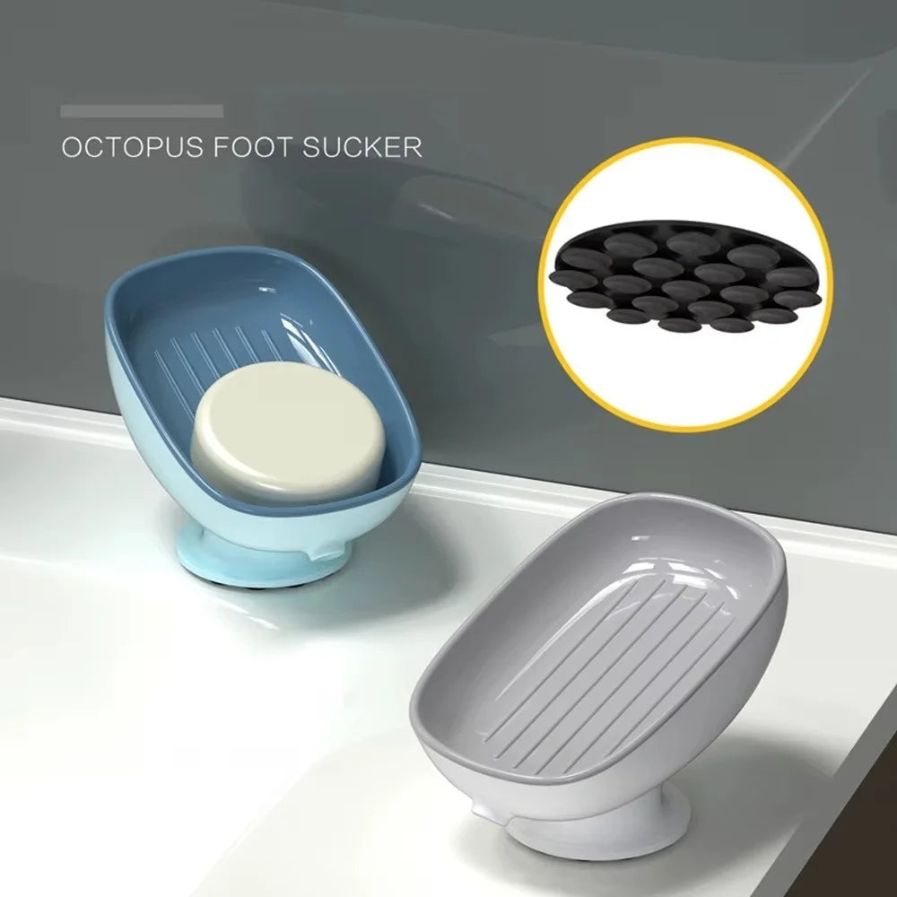 A blue suction cup soap holder with a white soap disc is shown next to a gray ceramic soap dish.