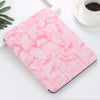 A pink marble patterned case for an iPad Pro with a built-in pencil holder resting on a white surface.