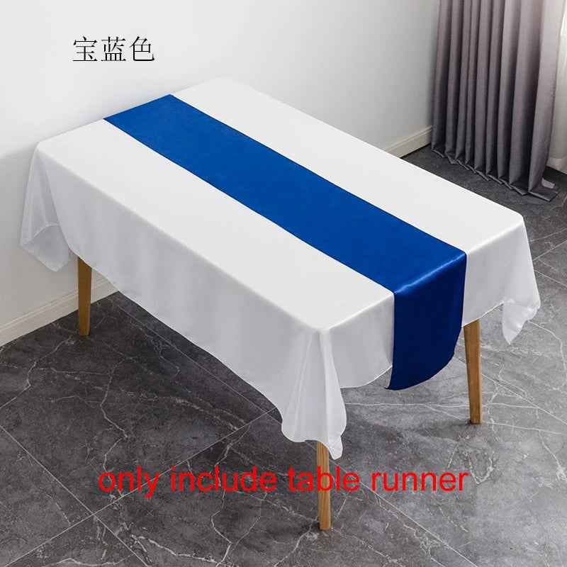 White tablecloth with a royal blue satin table runner displayed on a wooden table.