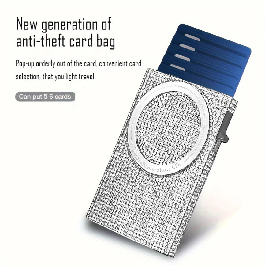 A silver aluminum pop-up card wallet with a clear circular window for holding cards.