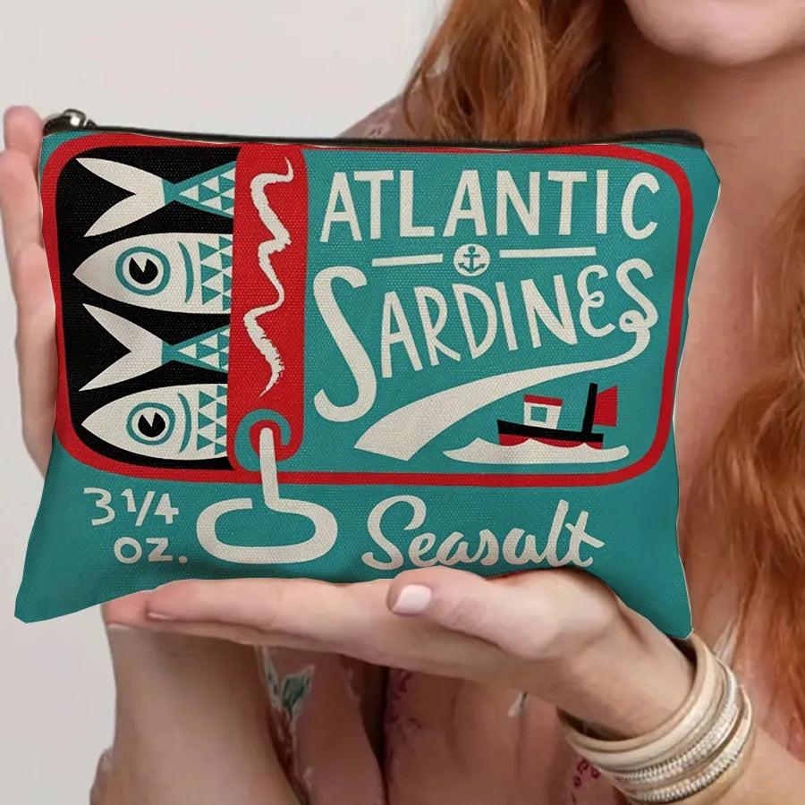 A teal canvas cosmetic bag featuring a vintage sardine print and the word Seasalt