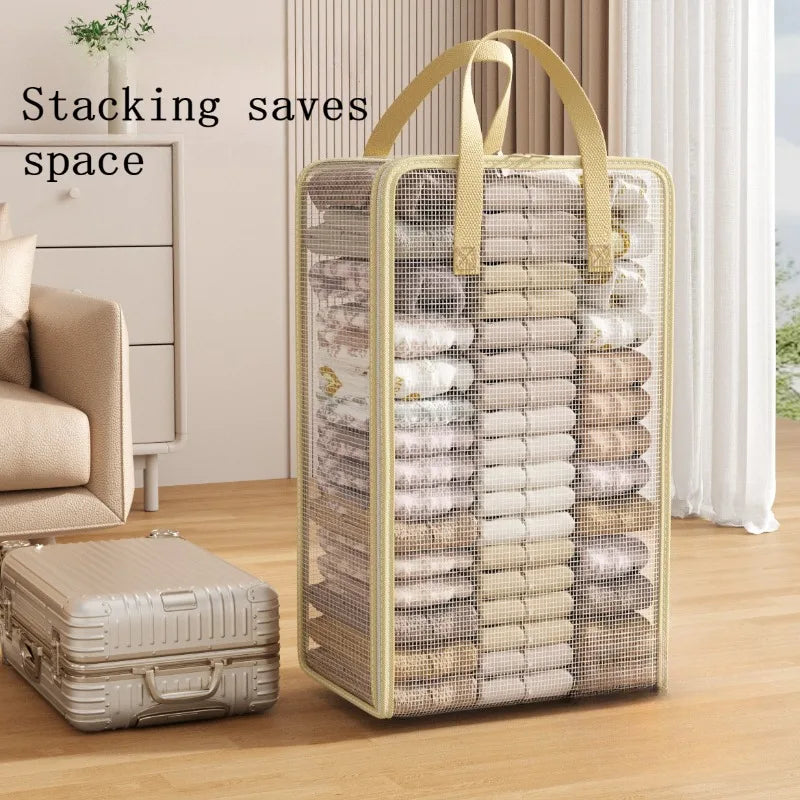 A vertical clear mesh storage bag with handles filled with neatly folded textiles like blankets and clothing.